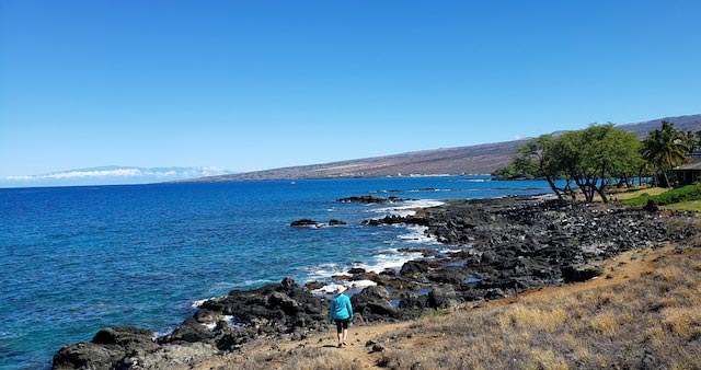 woman walking rocks ocean